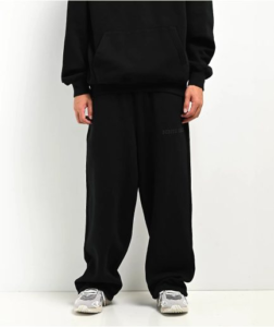 Product Title: Ninth Hall Premium Black Logo Essential Streetwear Sweatpants Product Description: The Ninth Hall Premium Black Logo Essential Streetwear Sweatpants deliver an effortless blend of modern streetwear style and ultimate everyday comfort from Ninth Hall. Featuring a classic black colorway accented by subtle, high-end signature logo detailing, these sweatpants bring an essential, versatile edge to your casual rotation. Crafted from heavy-weight, high-quality cotton fleece fabric, these Ninth Hall sweatpants offer a sturdy yet ultra-cozy feel built for daily wear or lounging in style. Designed with a relaxed, slouchy silhouette, they create a sharp aesthetic that stacks effortlessly over your favorite sneakers. Detailed with an adjustable drawcord waistband, ribbed cuffs, and convenient side pockets, these sweatpants pair naturally with oversized hoodies, graphic tees, or zip-up jackets. Finish your look with platform sneakers or heavy boots to complete the ultimate streetwear fit. Product Details Material: 100% Premium Cotton Fleece Blend Color: Black Fit: Relaxed / Slouchy Fit Style: Essential Streetwear Sweatpants Gender: Unisex Design: Signature Logo Accents & Clean Ribbed Cuffs How does the Ninth Hall Premium Black Logo Essential Streetwear Sweatpants fit? They feature a relaxed, roomy fit through the hips and thighs with a tapered leg and ribbed cuffs, giving you an effortless drape and secure comfort.